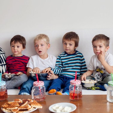 Four young boys sitting on a couch