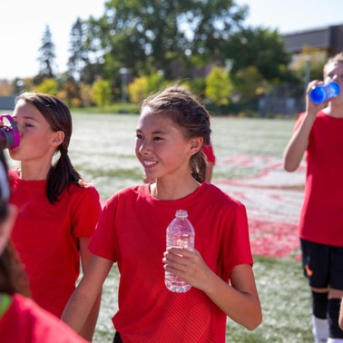 Teens drinking from water bottles