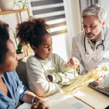 Doctor talking to a young girl and her mom