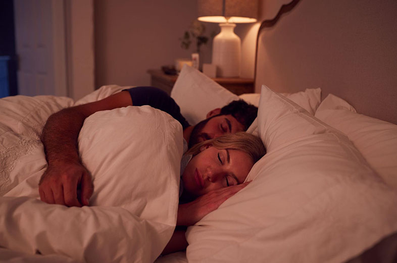 Man holding his partner in bed