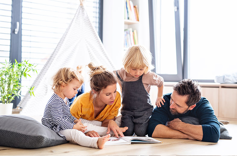 Mom and dad relaxing and reading to their children