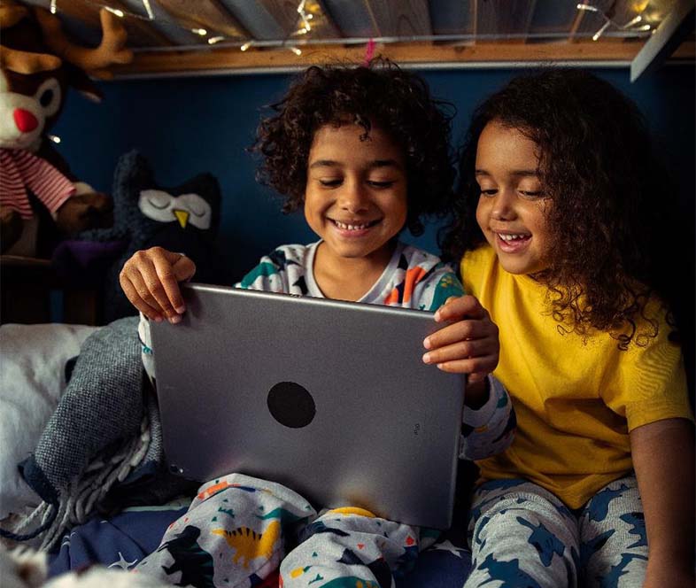 Smiling boy and girl looking at a laptop