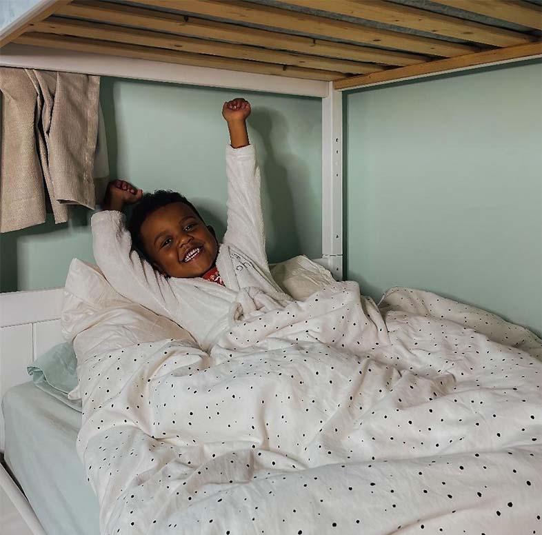 Smiling child stretching in bed