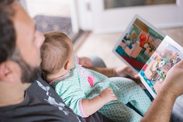 Father and small baby reading a story.