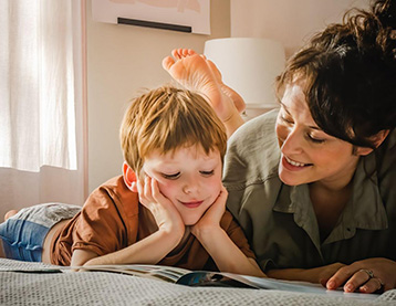 Mom and son lying on a bed reading